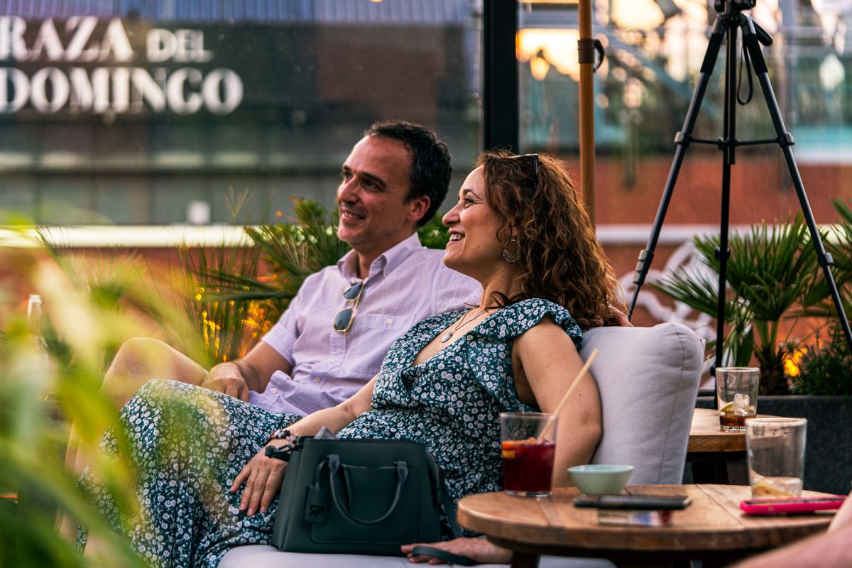 Un couple souriant boit un café à une terrasse