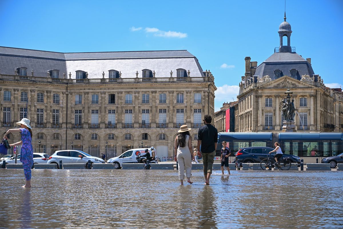 Des promeneurs profitent du miroir d’eau, place de la Bourse à Bordeaux