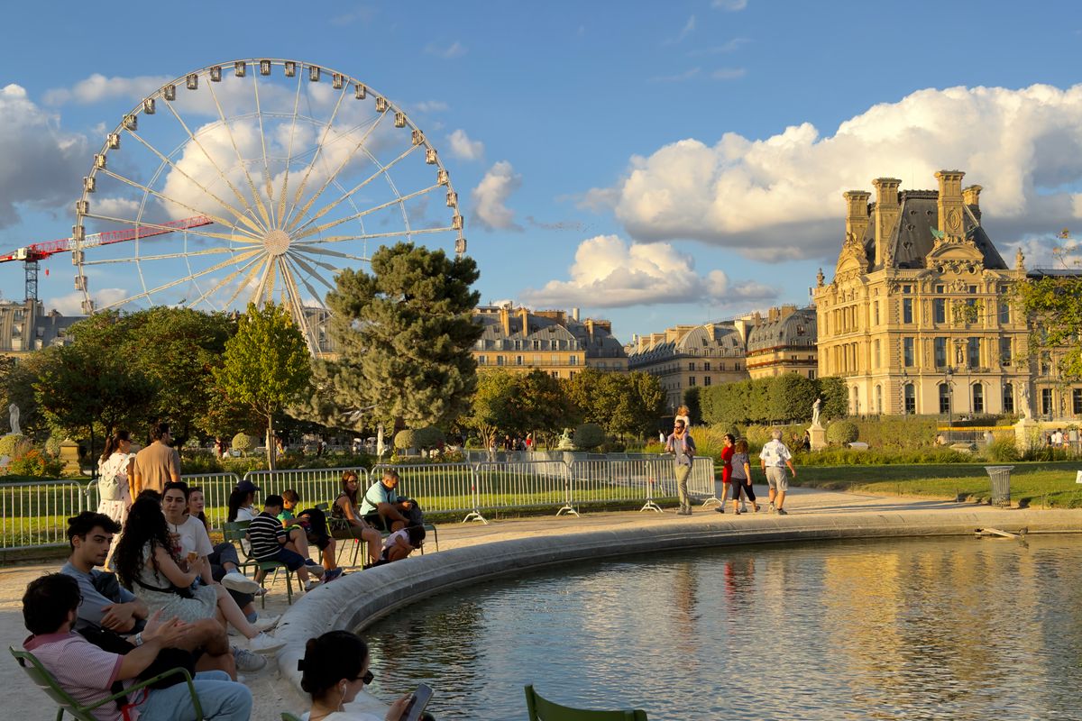 Des promeneurs se détendent autour du bassin du jardin des Tuileries à Paris