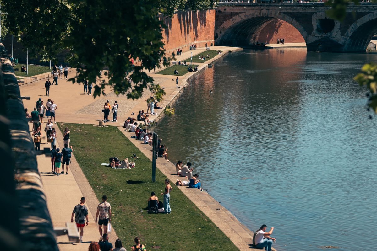 Des promeneurs profitent du soleil sur les quais de la Garonne à Toulouse